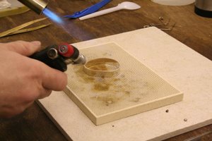 heating the silver hoop until the solder runs